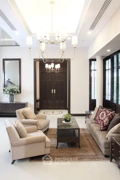 Elegant living room with plush seating, chandelier, and stylish decor in a luxurious home.