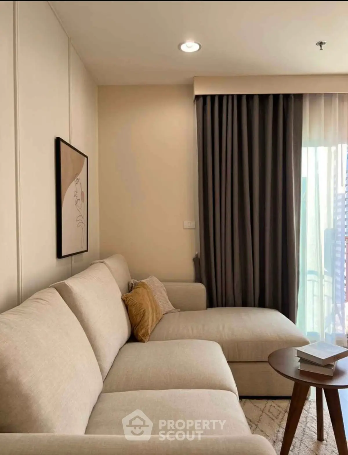 Cozy living room with beige sectional sofa and elegant curtains, perfect for relaxation.
