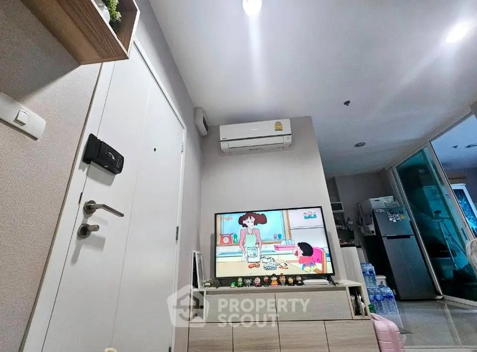 Modern living room with TV, air conditioning, and stylish decor in a cozy apartment setting.
