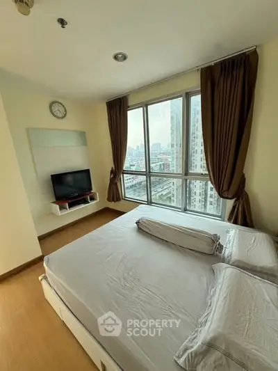 Spacious bedroom with city view and modern furnishings in high-rise apartment