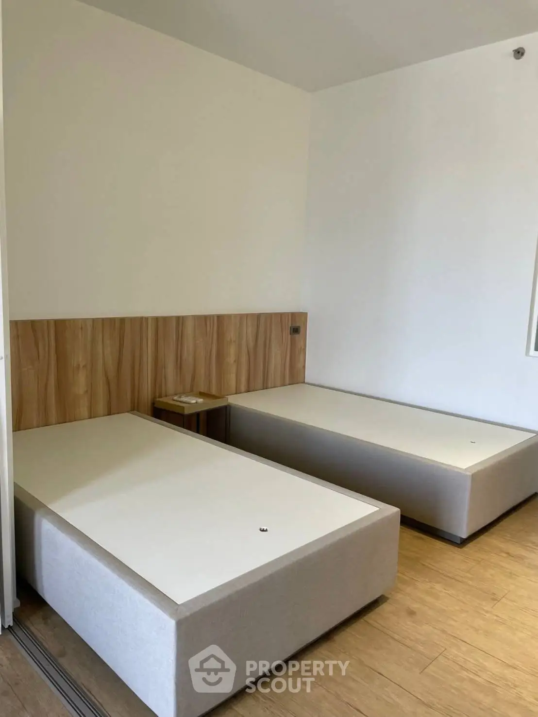 Modern minimalist bedroom with twin beds and wooden flooring