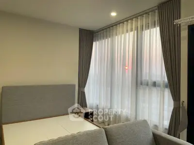 Modern bedroom with stylish curtains and cozy bed, featuring a serene sunset view.