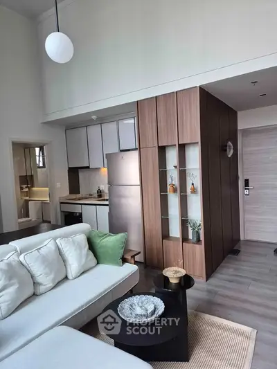 Modern open-plan living room with stylish kitchen and cozy seating area in a contemporary apartment.