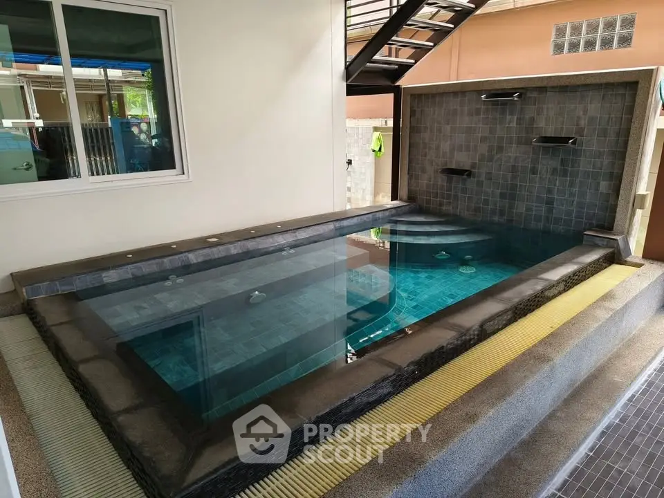 Luxurious indoor pool with modern stone design and waterfall feature