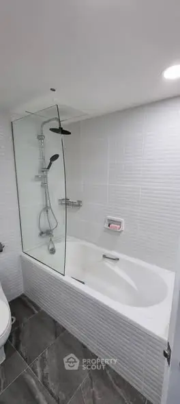 Modern bathroom with bathtub and glass shower partition