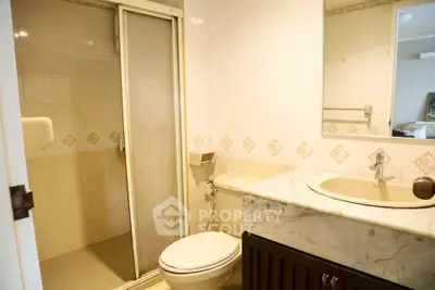 Charming bathroom with elegant marble countertop and modern shower enclosure.