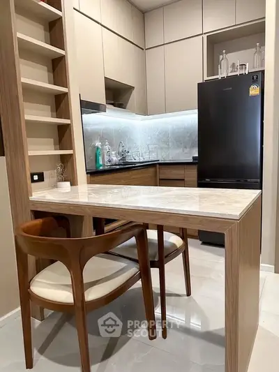 Modern kitchen with sleek cabinetry and dining area in compact layout