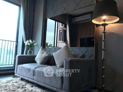 Modern living room with plush sofa and elegant lamp near balcony view.