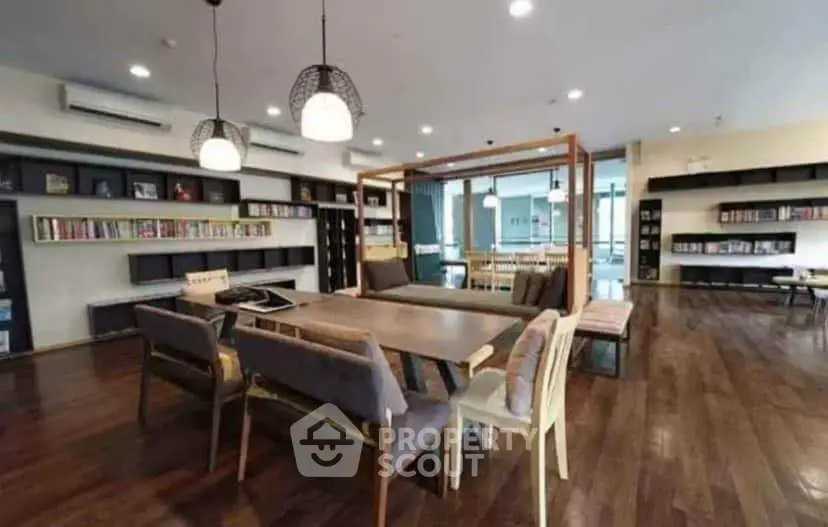 Spacious modern library with wooden flooring and ample seating in a contemporary building.