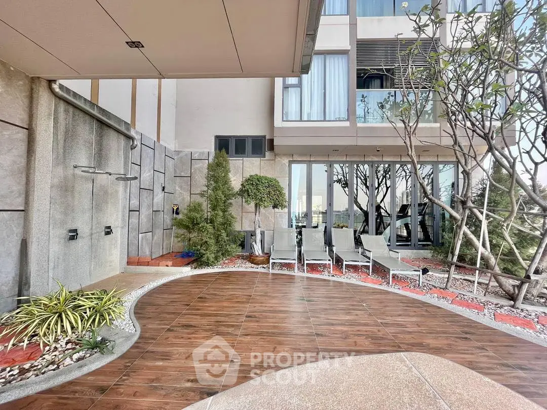 Modern building exterior with stylish patio and lounge chairs, perfect for relaxation.