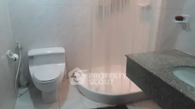 Modern bathroom with sleek shower and elegant granite countertop.