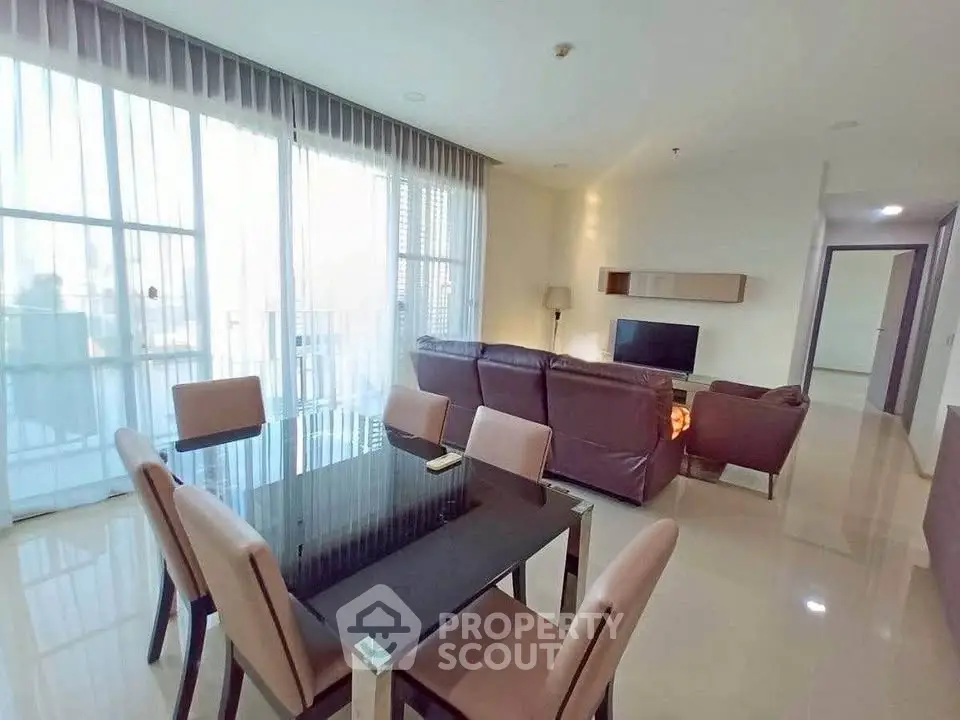 Spacious modern living room with dining area and large windows in a stylish apartment.