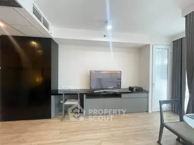 Modern living room with sleek TV setup and stylish furniture in a contemporary apartment.