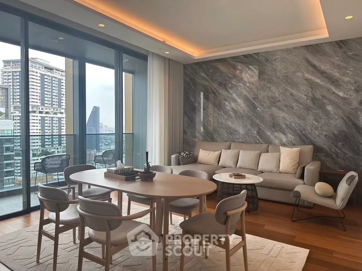 Luxurious living room with modern furniture and stunning city view from large balcony.