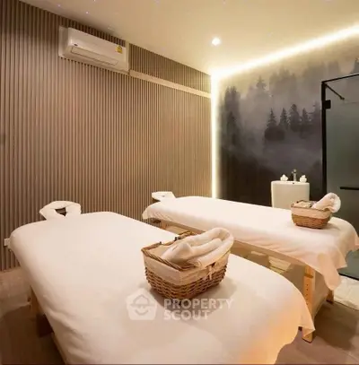Luxurious spa room with massage tables and serene forest wall art, perfect for relaxation and rejuvenation.