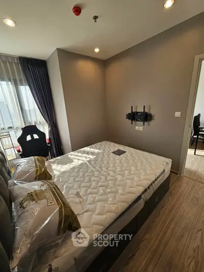 Modern bedroom with natural light, featuring a comfortable bed and stylish decor.