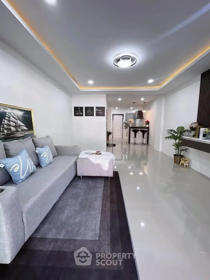 Modern living room with sleek design and open layout, featuring stylish furniture and elegant lighting.