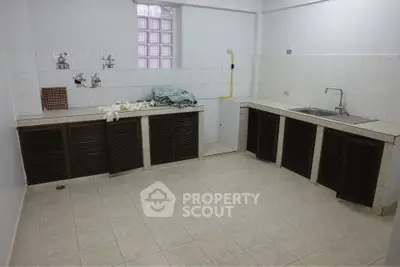 Spacious kitchen with tiled flooring and ample storage cabinets