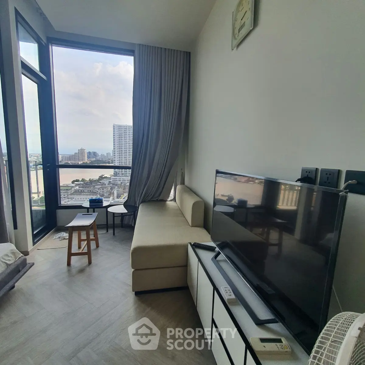 Modern living room with stunning city view, featuring sleek furniture and large windows for natural light.