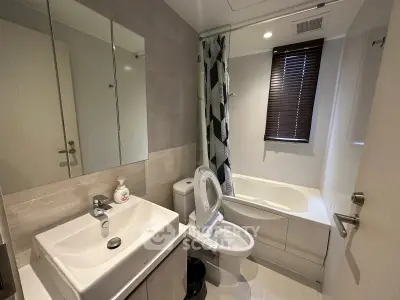 Modern bathroom with bathtub, sink, and stylish decor in a contemporary apartment.