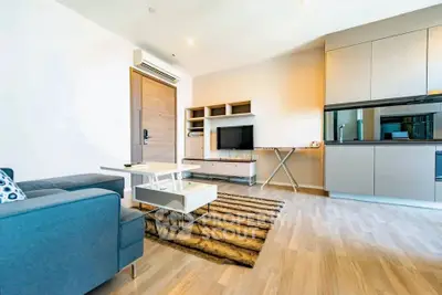 Modern living room with sleek furniture and open kitchen layout in a stylish apartment.