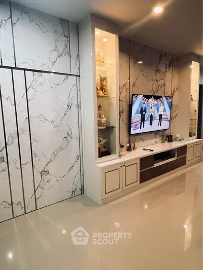Luxurious living room with marble accents and built-in TV unit, perfect for modern living.