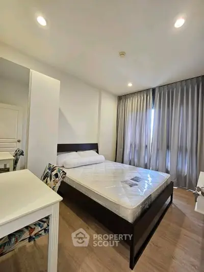 Modern bedroom with stylish decor and natural light, featuring a comfortable bed and elegant furnishings.