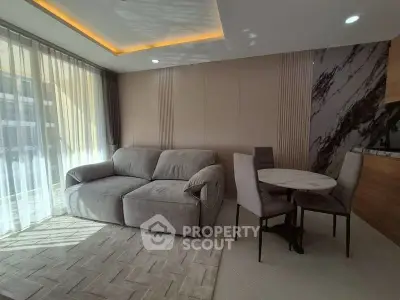 Modern living room with cozy sofa and dining area, featuring elegant lighting and stylish decor.