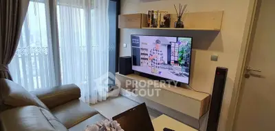 Modern living room with TV and balcony view, cozy seating and stylish decor.