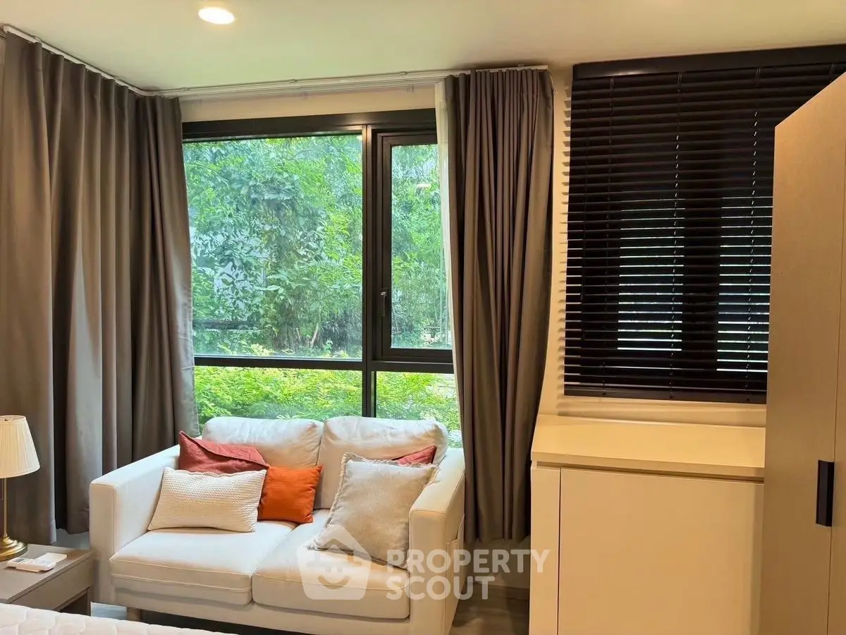 Cozy living room with large windows and elegant curtains, perfect for relaxation.