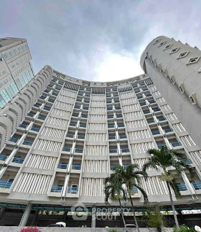 Stunning architectural high-rise building with modern design and palm trees in foreground.