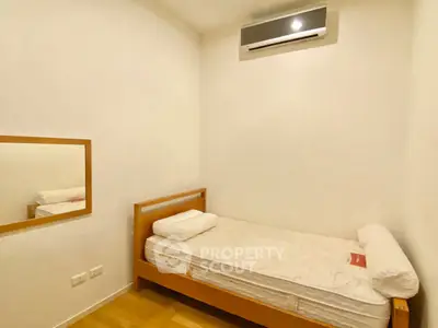 Cozy minimalist bedroom with single bed and wall-mounted air conditioner