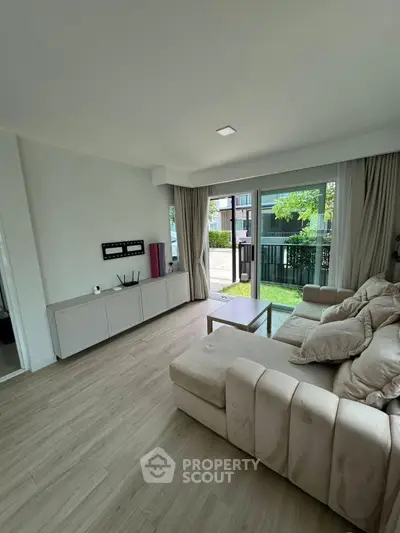 Spacious living room with modern decor and garden view, perfect for relaxation and entertaining.