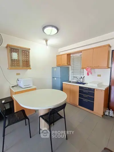 Cozy kitchen with modern appliances and dining area in a bright apartment.