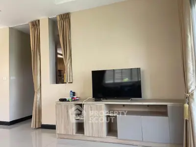 Modern living room with TV and stylish wooden cabinet, featuring elegant curtains and neutral tones.