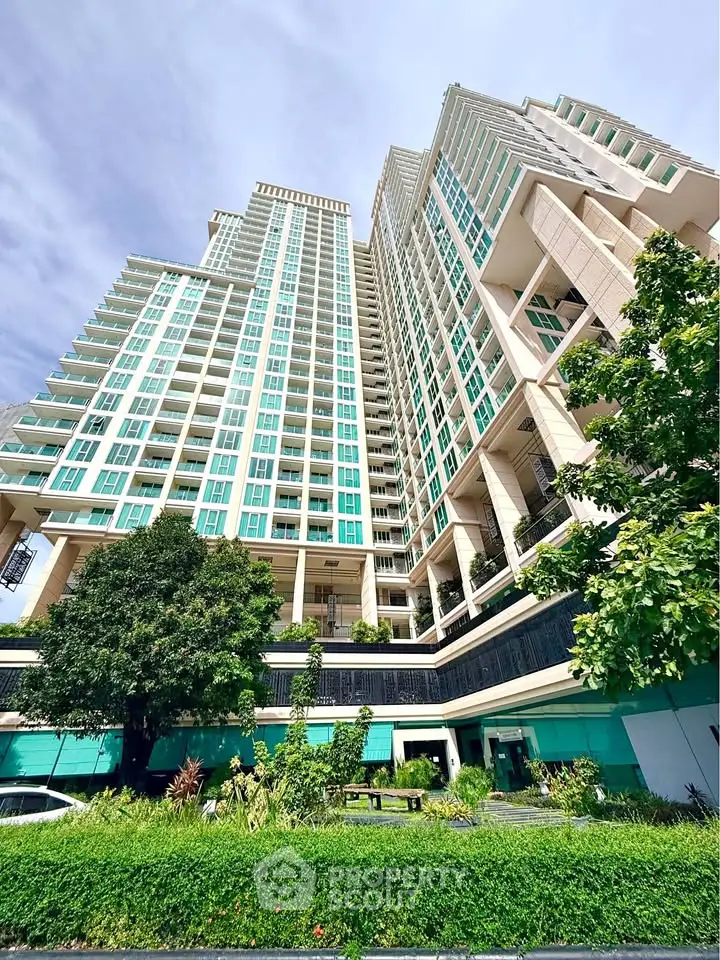 Stunning high-rise building with modern architecture and lush landscaping, perfect for urban living.