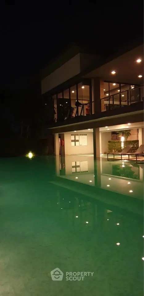 Luxurious night view of a modern home with illuminated poolside ambiance.