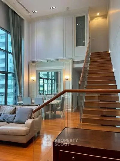 Luxurious duplex living room with high ceilings and elegant staircase