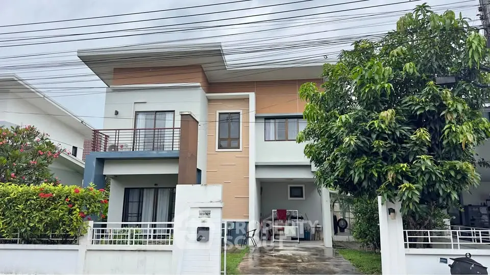 Modern two-story house with lush garden and spacious driveway in suburban neighborhood.