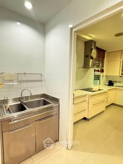 Spacious kitchen with modern stainless steel sink and ample storage in a contemporary home.