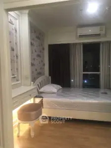 Cozy bedroom with elegant decor and large window offering natural light.