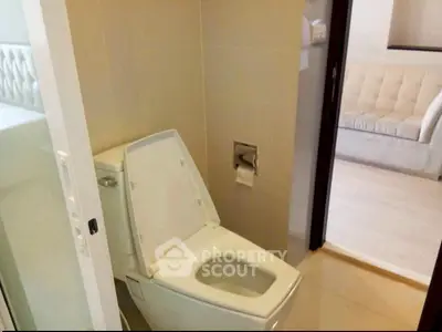Modern bathroom with sleek toilet design and view into cozy living room