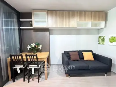 Modern living room with stylish sofa and dining area, featuring elegant wooden cabinetry and contemporary decor.
