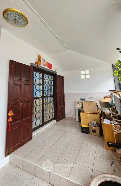 Charming entrance with traditional wooden doors and tiled flooring, perfect for a cozy home.