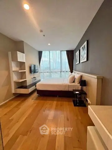 Modern bedroom with wooden flooring and large window offering city view