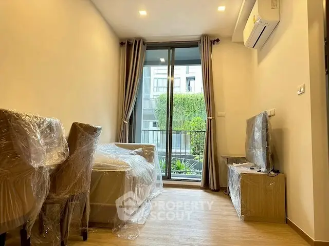 Modern living room with balcony view, featuring air conditioning and stylish furniture.