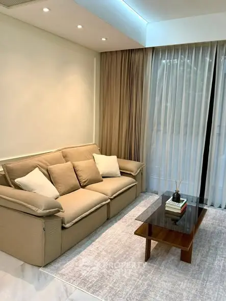 Stylish living room with modern beige sofa and elegant glass coffee table.