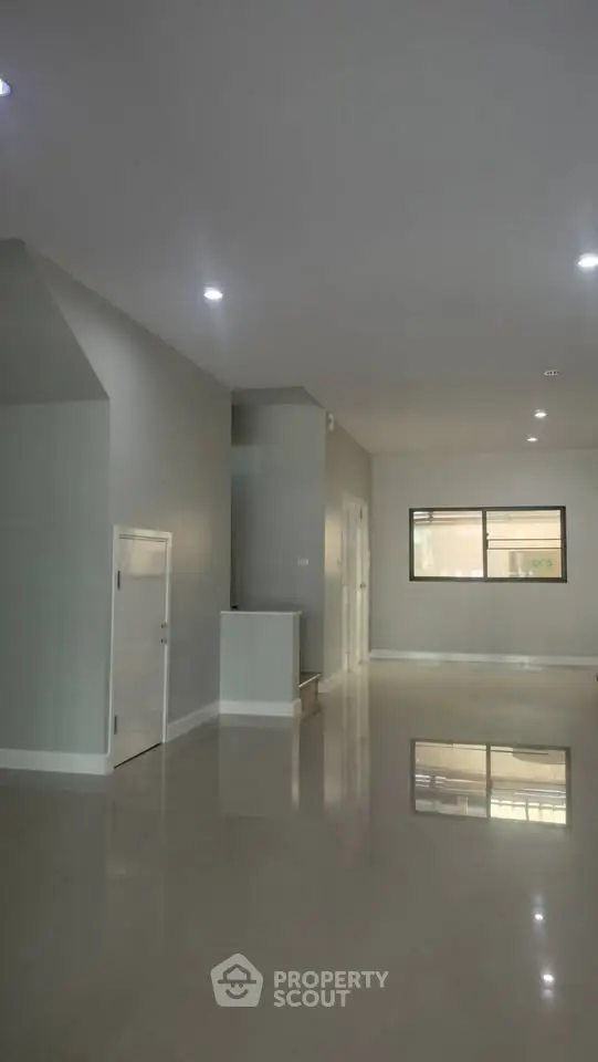 Spacious modern living room with sleek flooring and ample natural light