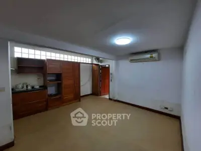 Spacious living room with wooden cabinets and air conditioning in modern apartment.