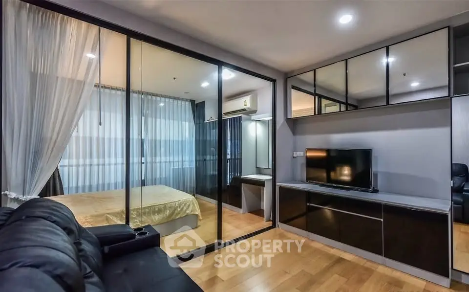 Modern living room with glass partition and bedroom view